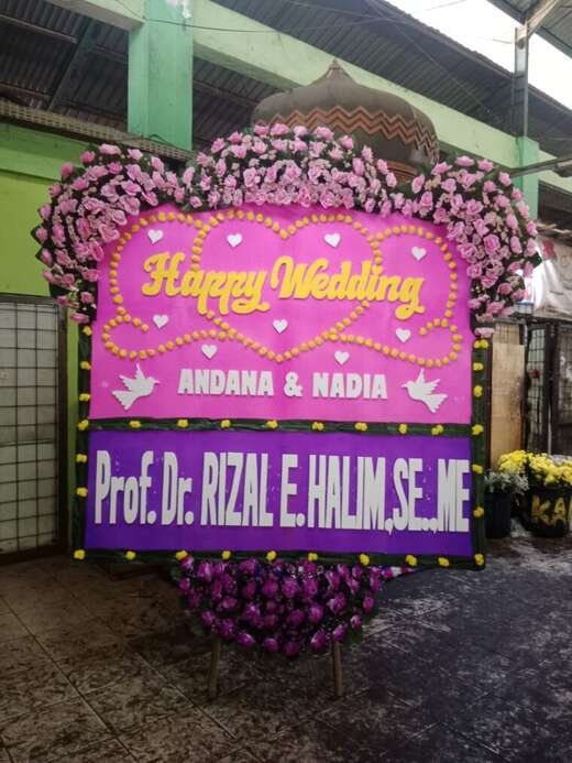 Bunga papan happy wedding warna merah muda & ungu, jambul 3 ukuran 1,5 × 2 m — kode EBW-D-06